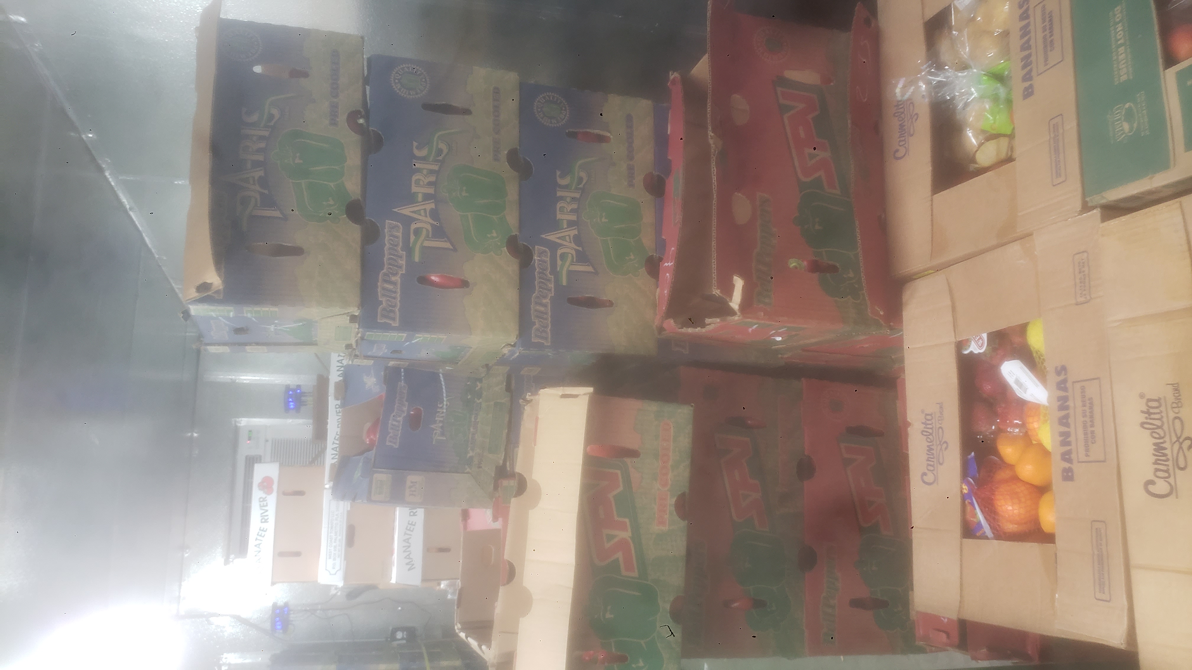 Boxes of tomatoes, boxes of bell peppers, and assorted produce banana boxes.
